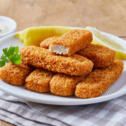 Fish Finger Close up of a fish sticks with lemon slices, served on a dark brown wooden kitchen table